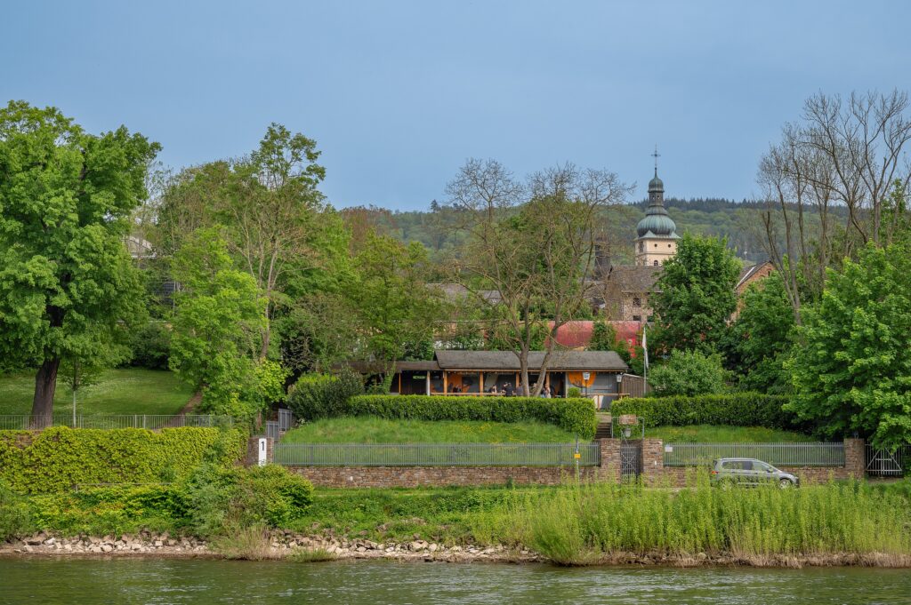 August ‒ Blick vom Schiff auf das Horchheimer Anglerheim - die idyllische Rheinansicht von der Wasserseite. ‒ Foto: Jürgen Dewald